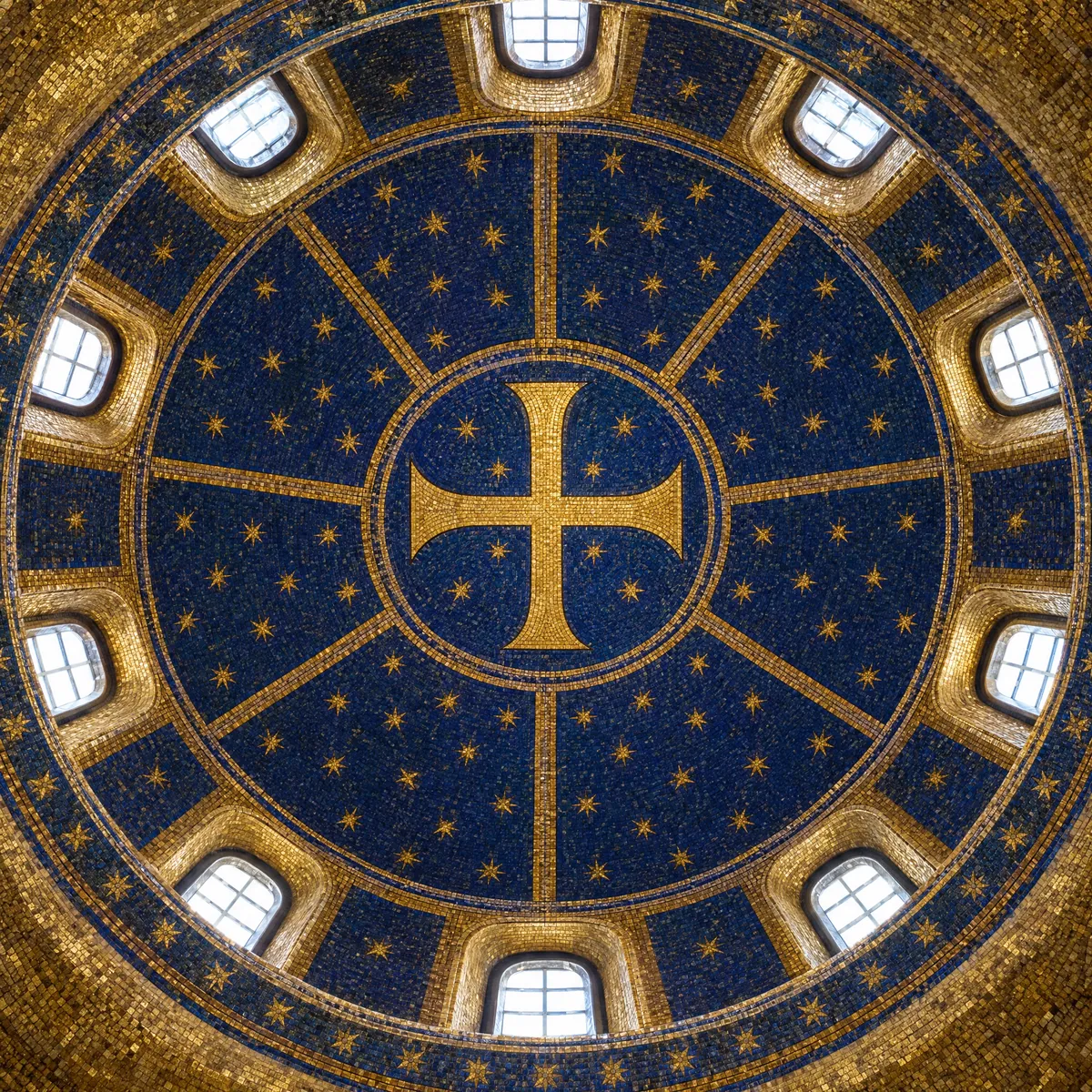 A gold cross on a field of gold stars in a mosaic dome